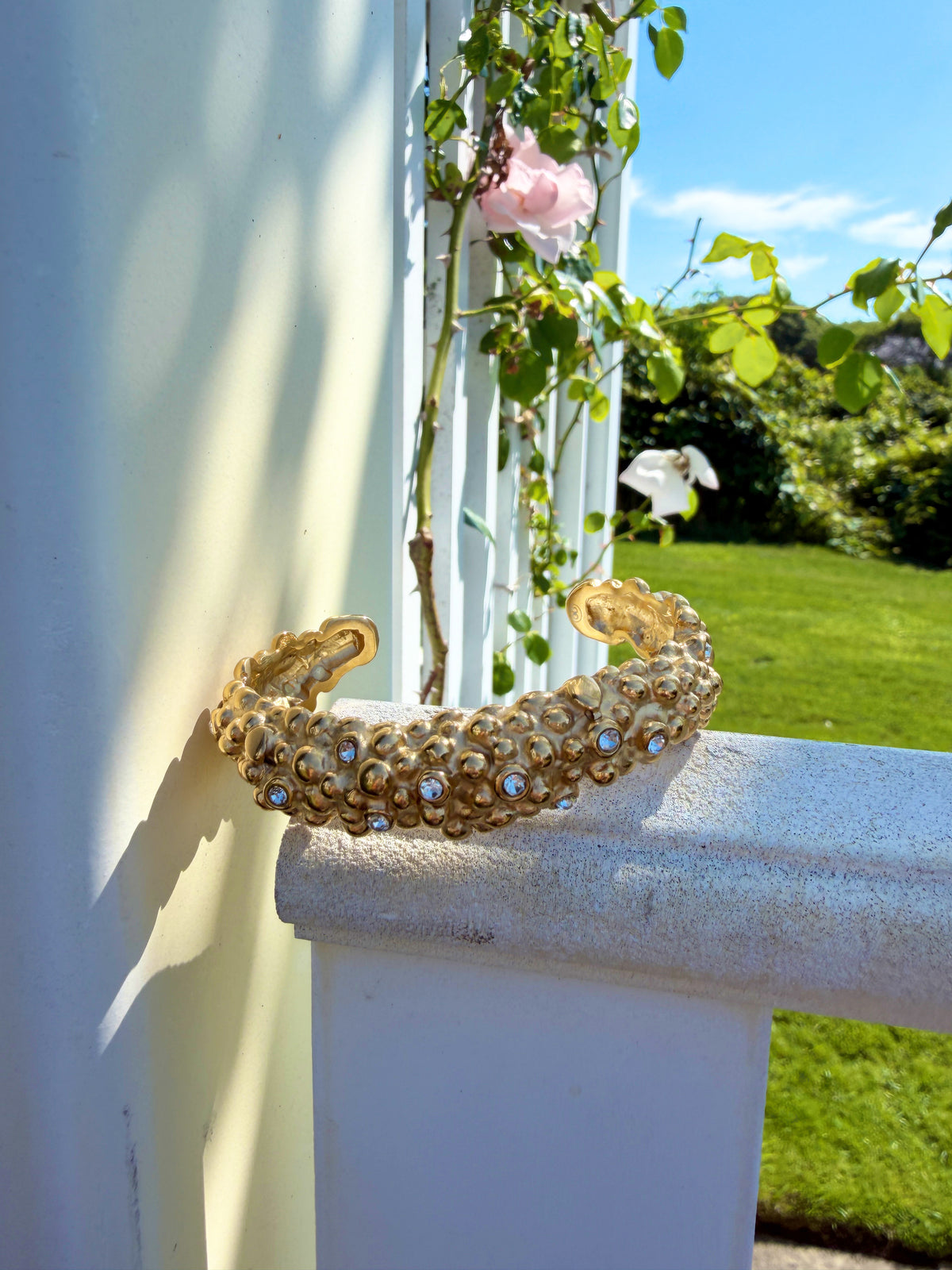 Textured gold cuff resting on a porch railing