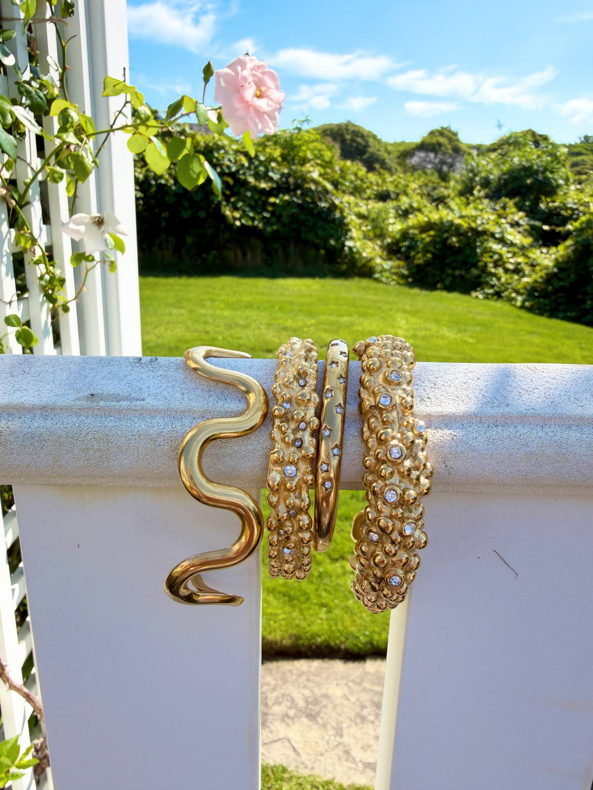 Gold cuff bracelet assortment in sunlight