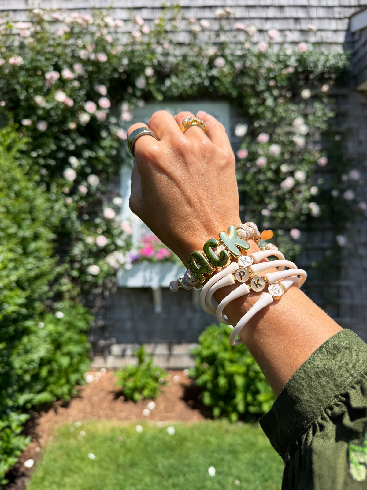 Layered bracelets worn on a raised wrist outdoors