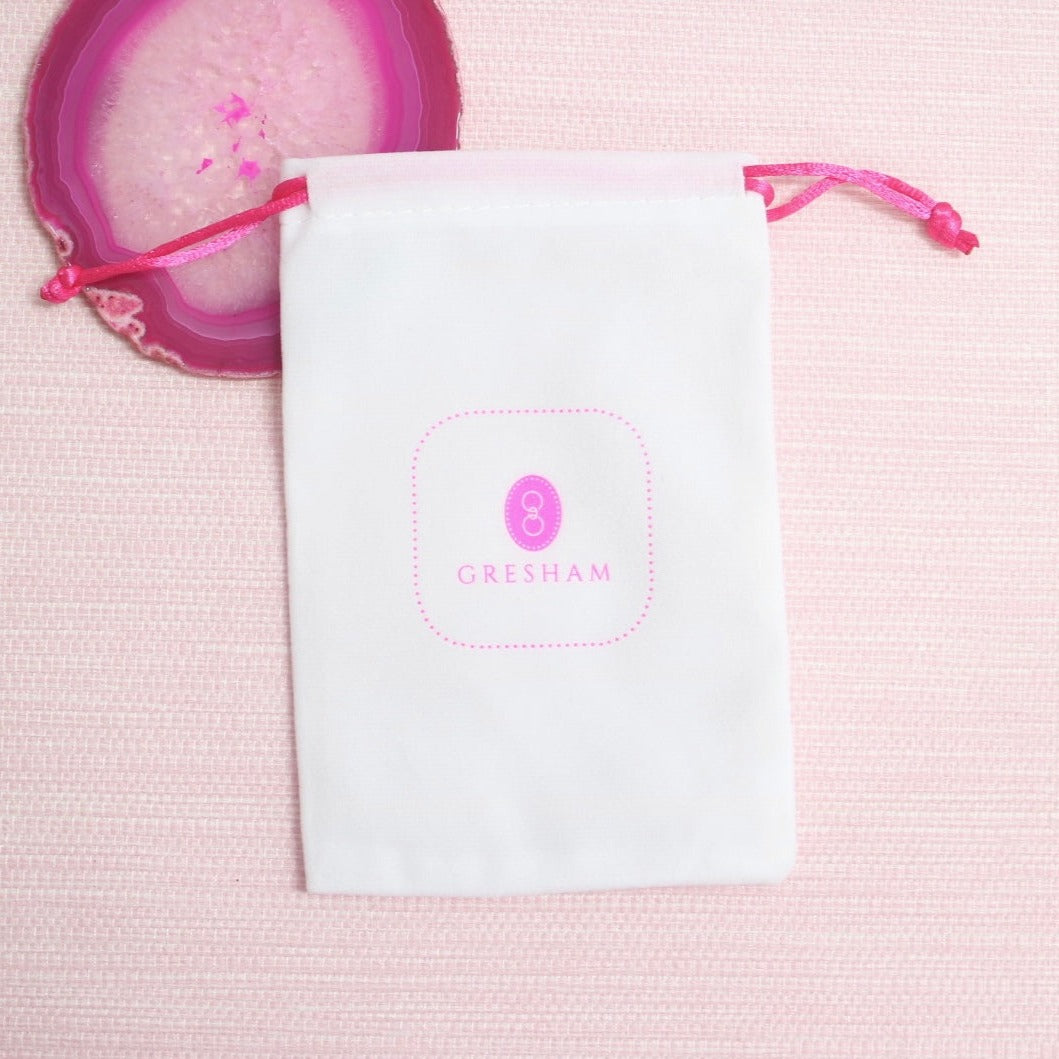 White drawstring Gresham jewelry pouch with pink logo