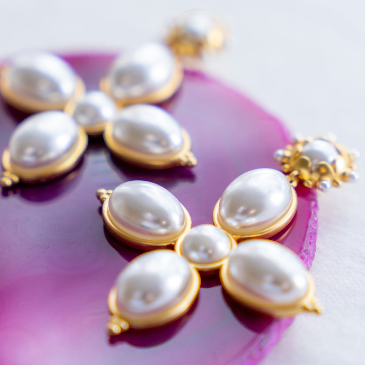 Close-up of oval pearls in the Grande Constance cross earrings