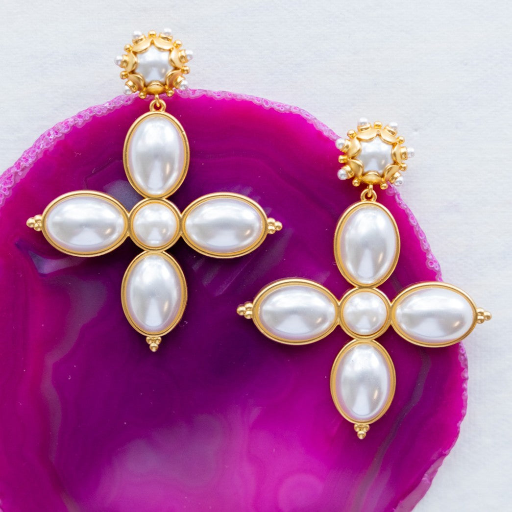 Grande Constance pearl cross earrings on a pink agate slice