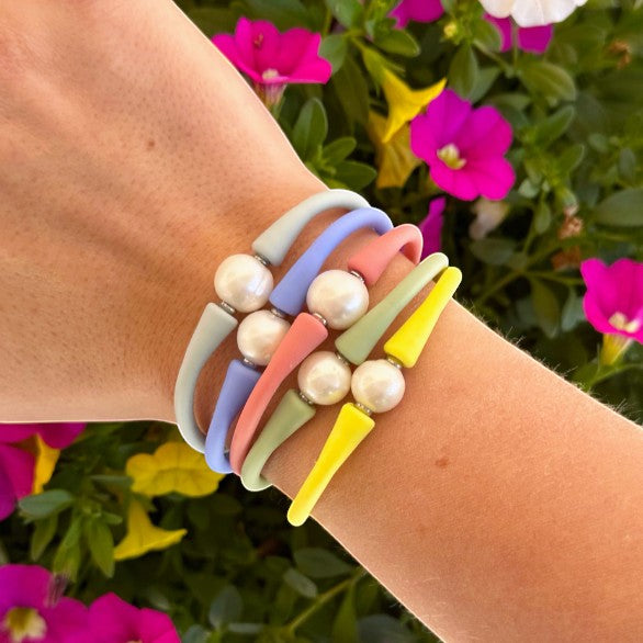 Wrist wearing a colorful stack of Maui pearl bracelets