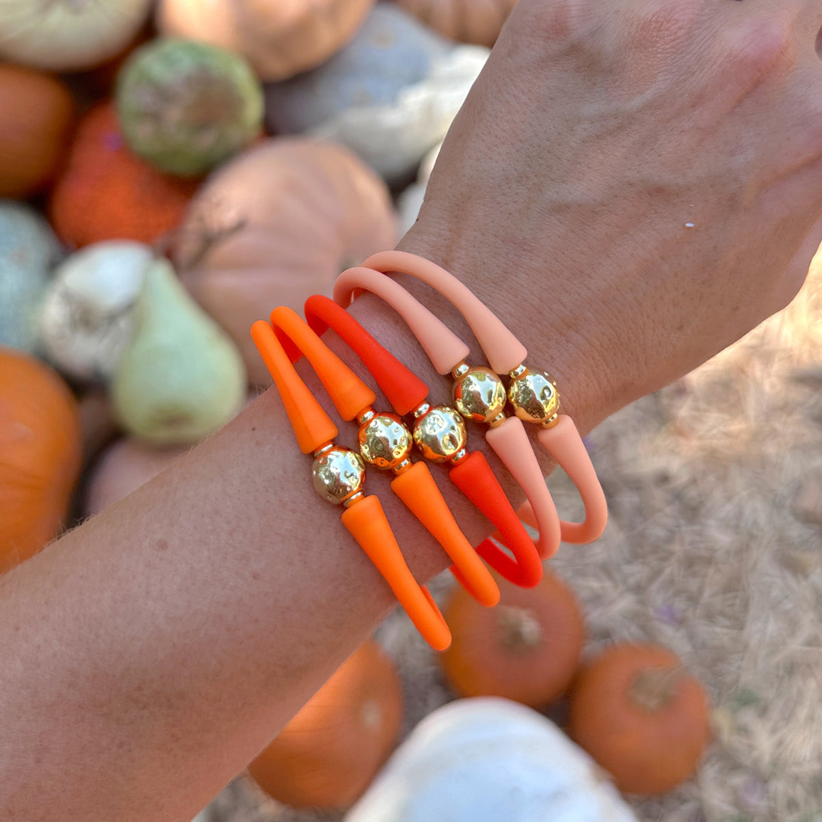 Wrist wearing several orange silicone bracelets