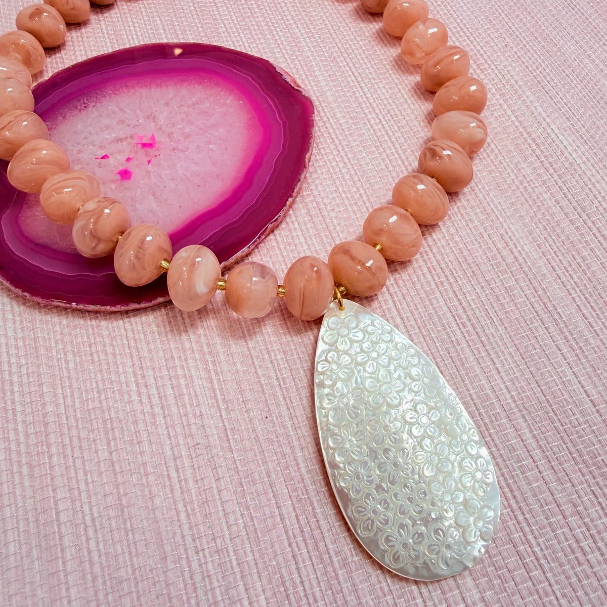 Close-up of a teardrop pendant on the pink Nardo necklace