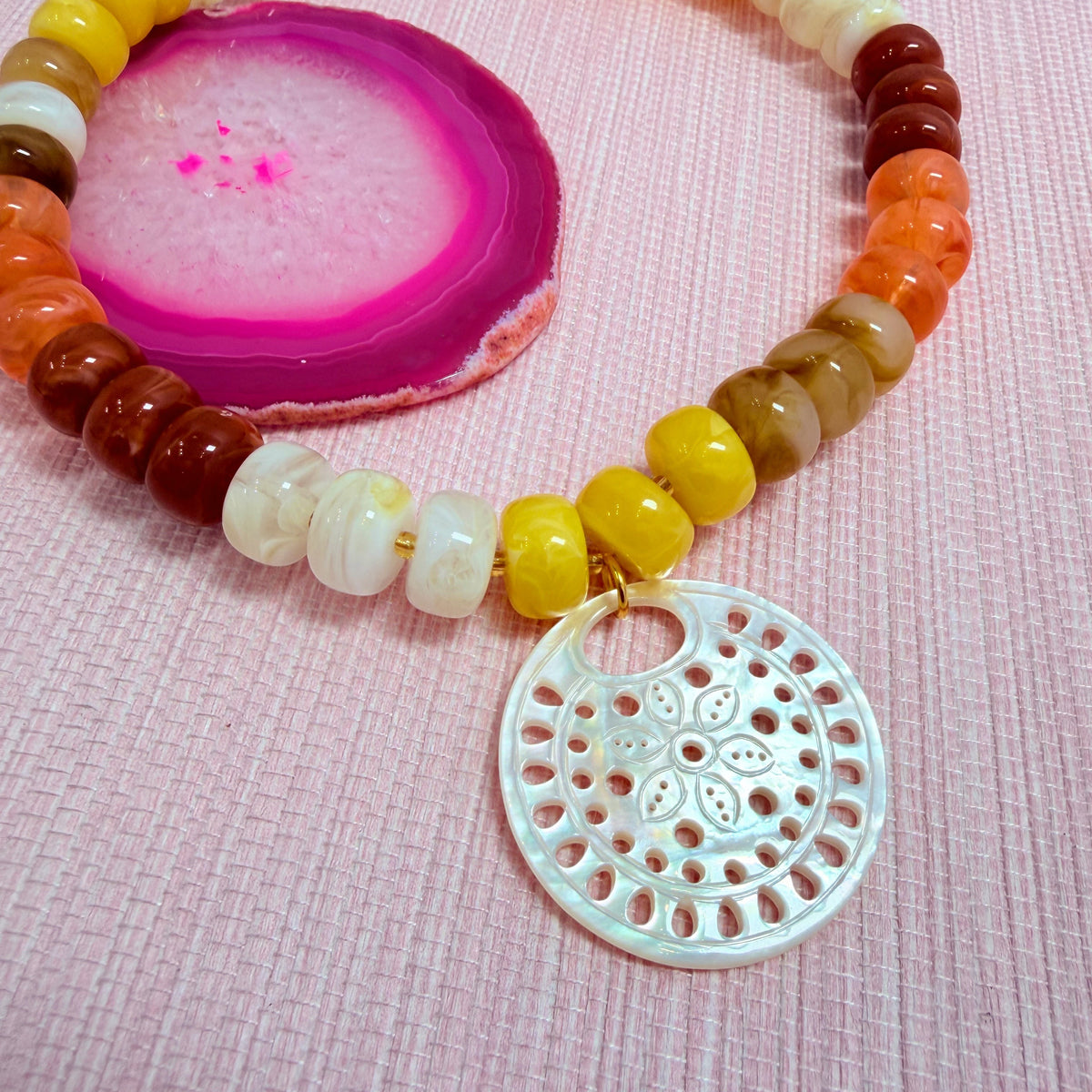 Close-up of a round pendant on the sunset Nardo necklace