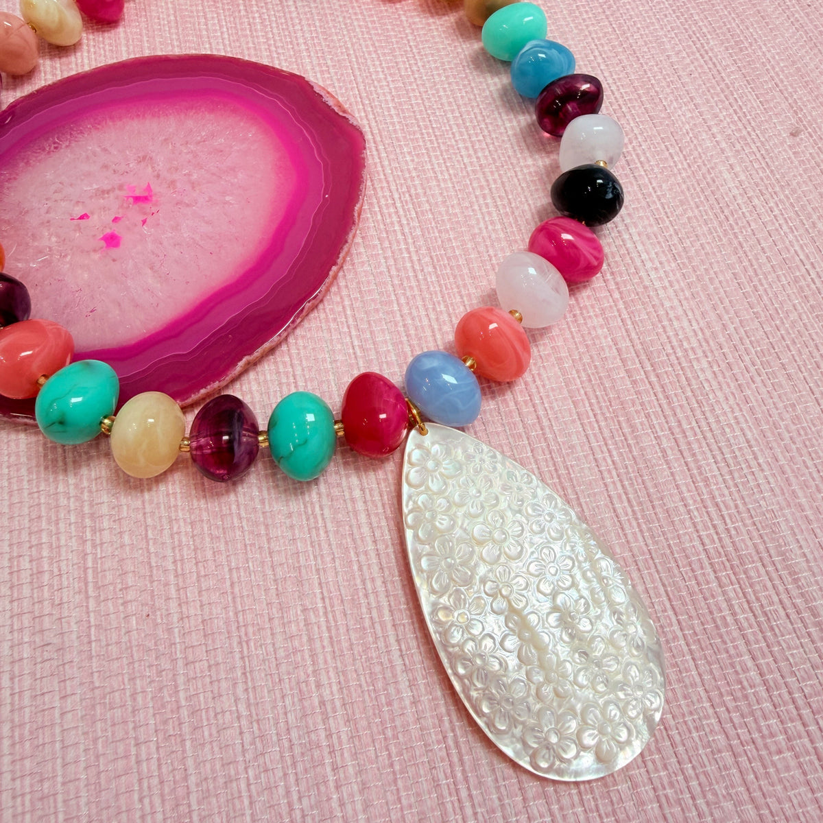Close-up of a teardrop pendant on the rainbow Nardo necklace