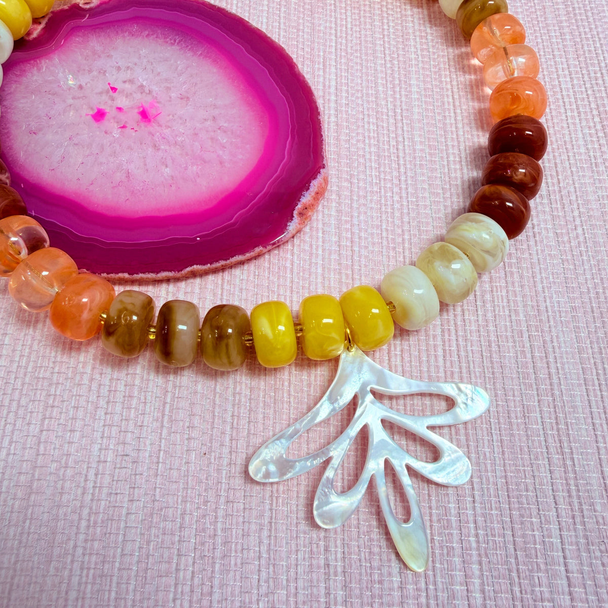 Close-up of a fan shaped pendant on the sunset Nardo necklace