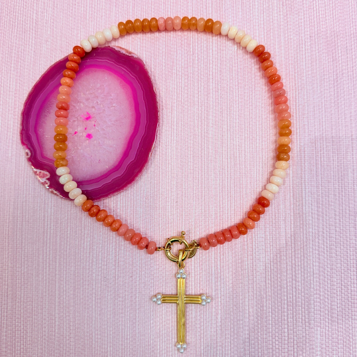 Orange Amalfi beaded necklace styled with a gold cross pendant