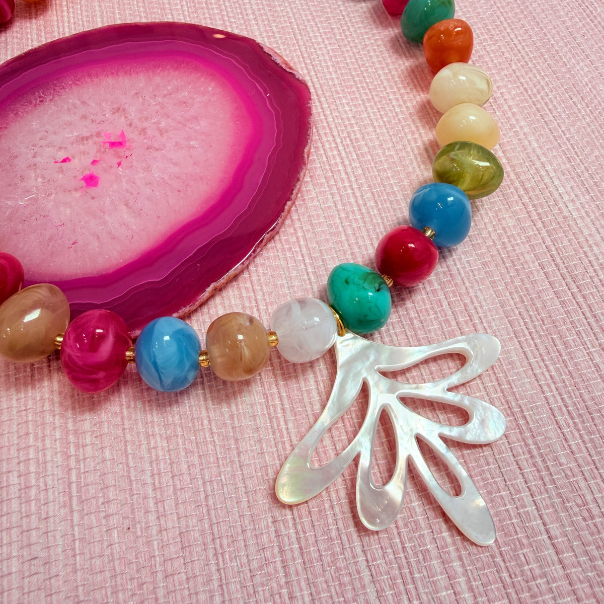 Close-up of a fan shaped pendant on the rainbow Nardo necklace