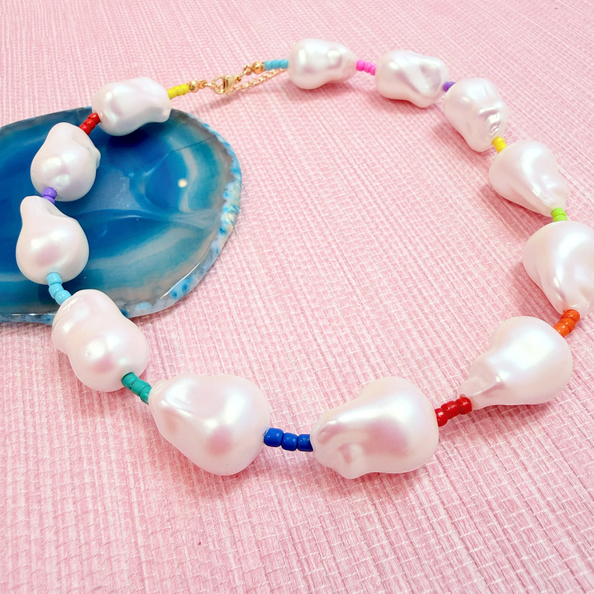 Close-up of white pearls and colorful beads on the Rocco Rainbow necklace