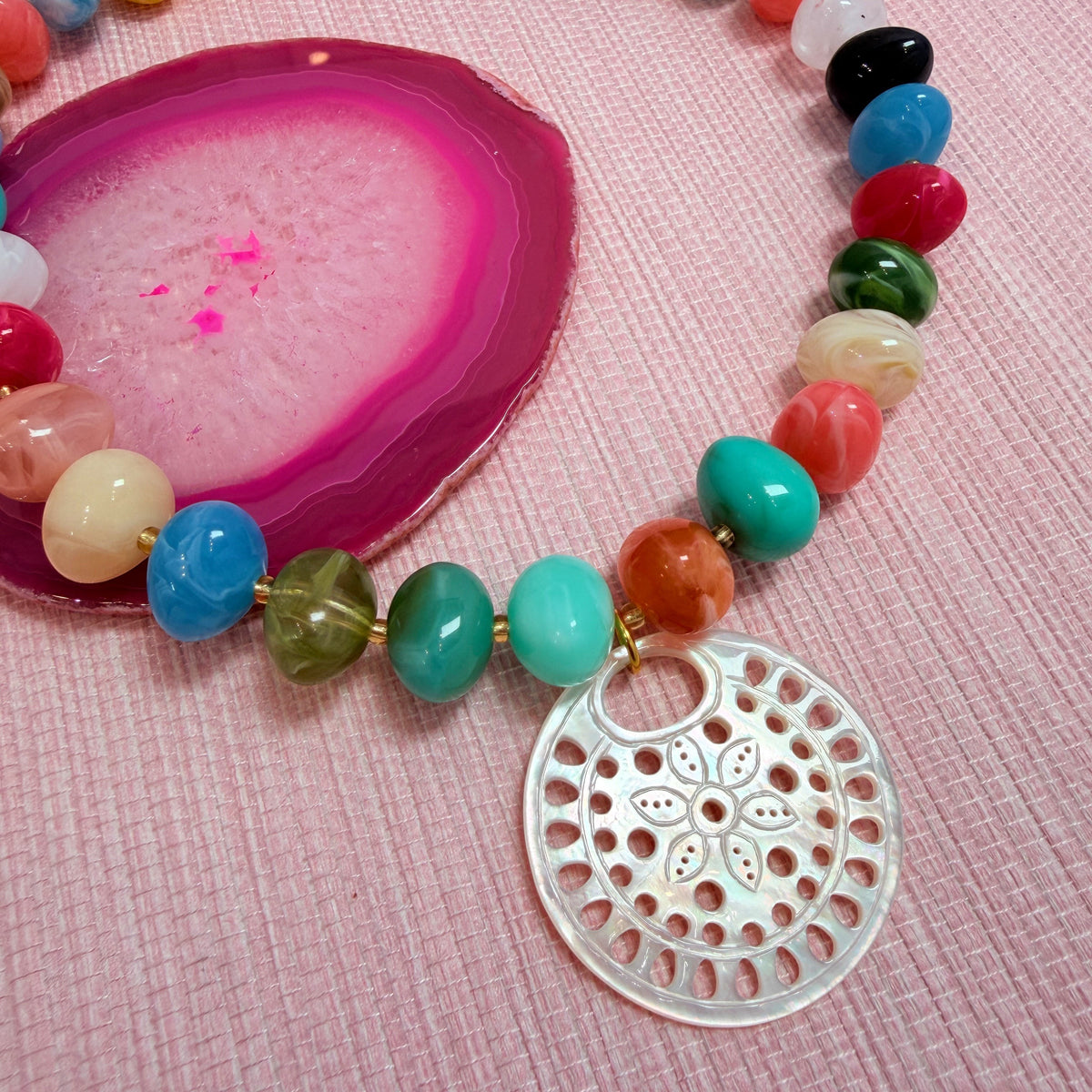 Close-up of a round pendant on the rainbow Nardo necklace