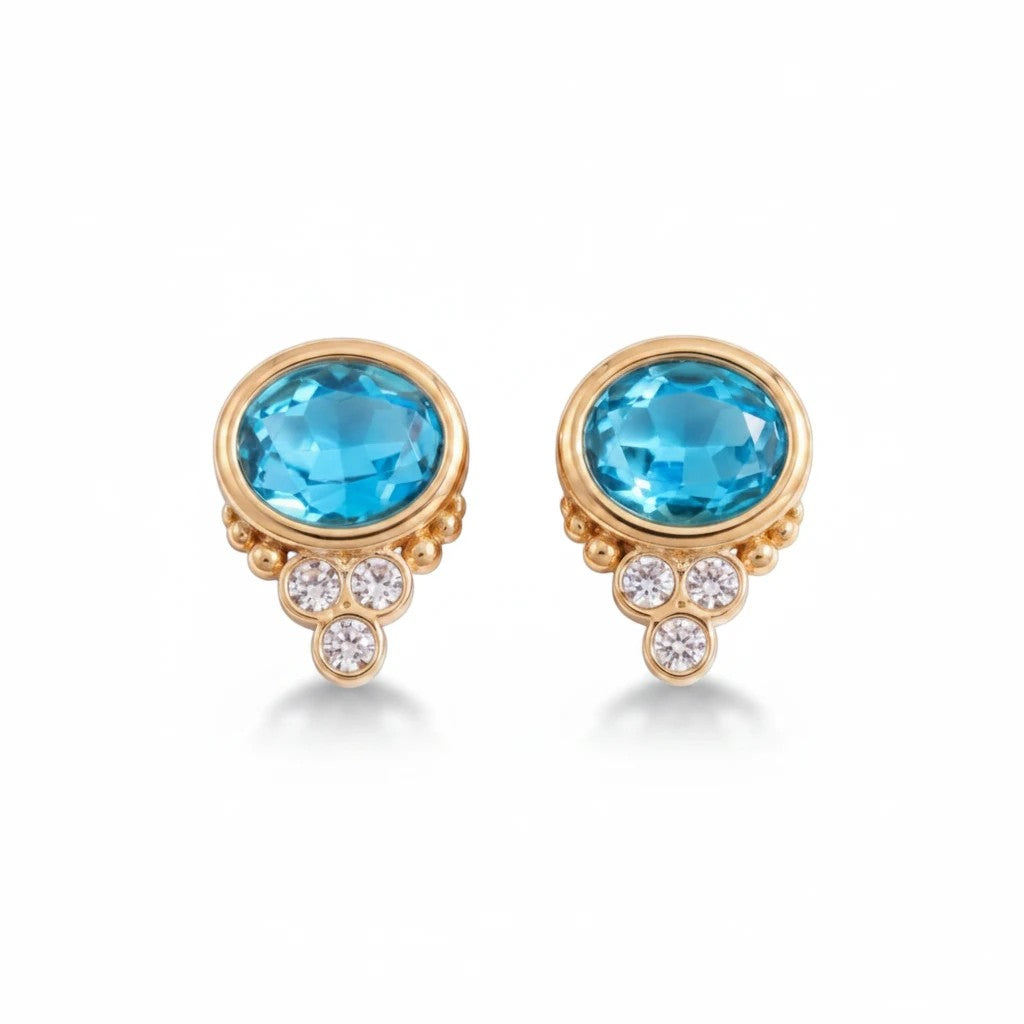 Gresham BonBon stud earrings featuring oval blue topaz stones accented with small white diamonds in gold settings.