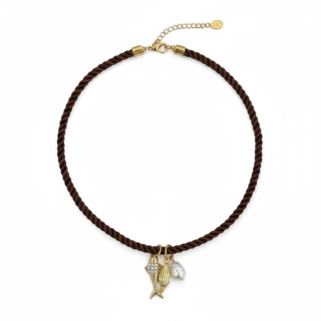 Gresham Jingle necklace featuring a brown twisted silk rope with three gold-plated charms and a pearl pendant.
