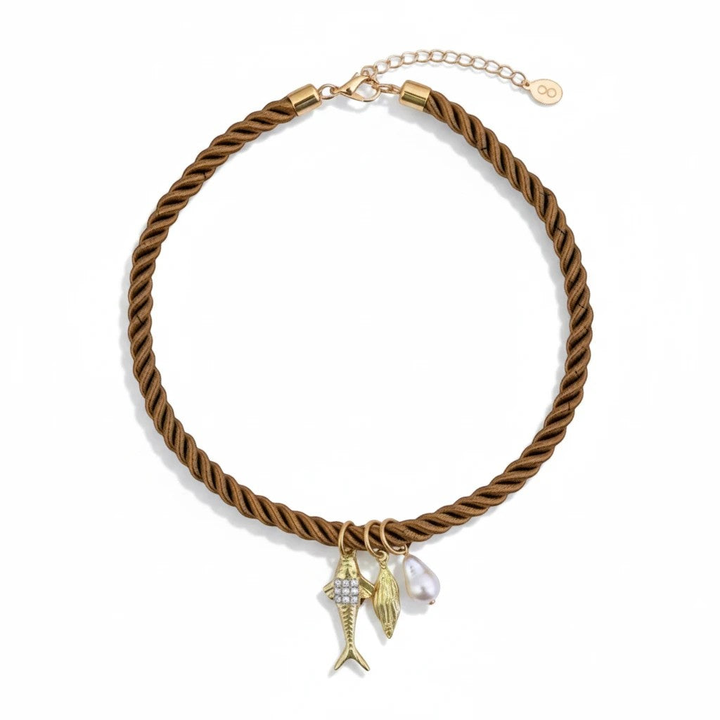 Gresham Jingle necklace featuring a brown twisted silk rope with gold plated fish, leaf, and pearl charms.