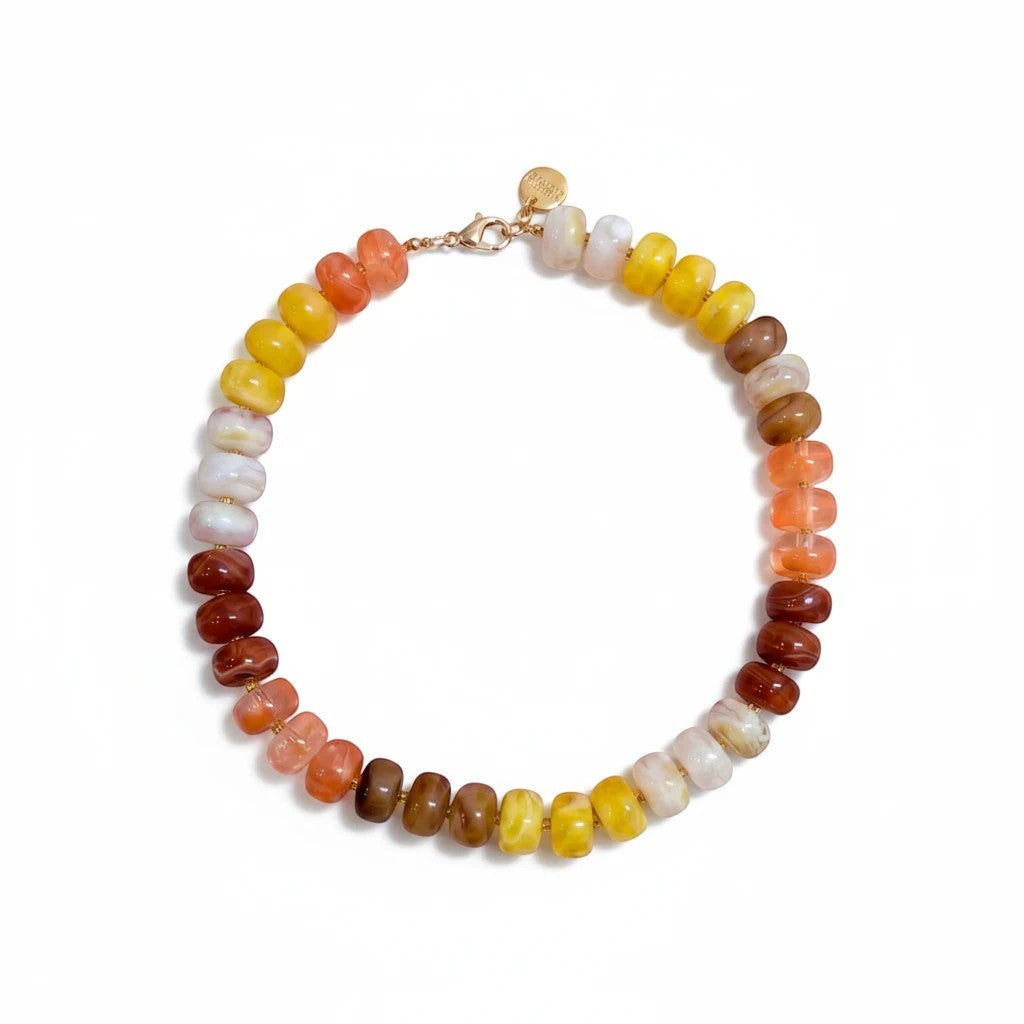 Gresham Nardo necklace in Sunset featuring large resin beads in a gradient of orange, yellow, and brown tones.