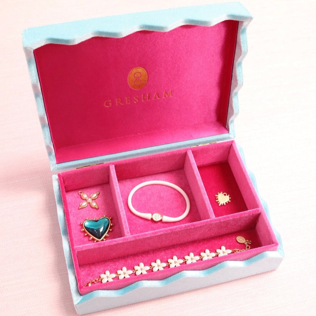 Open pink jewelry box with divided storage compartments