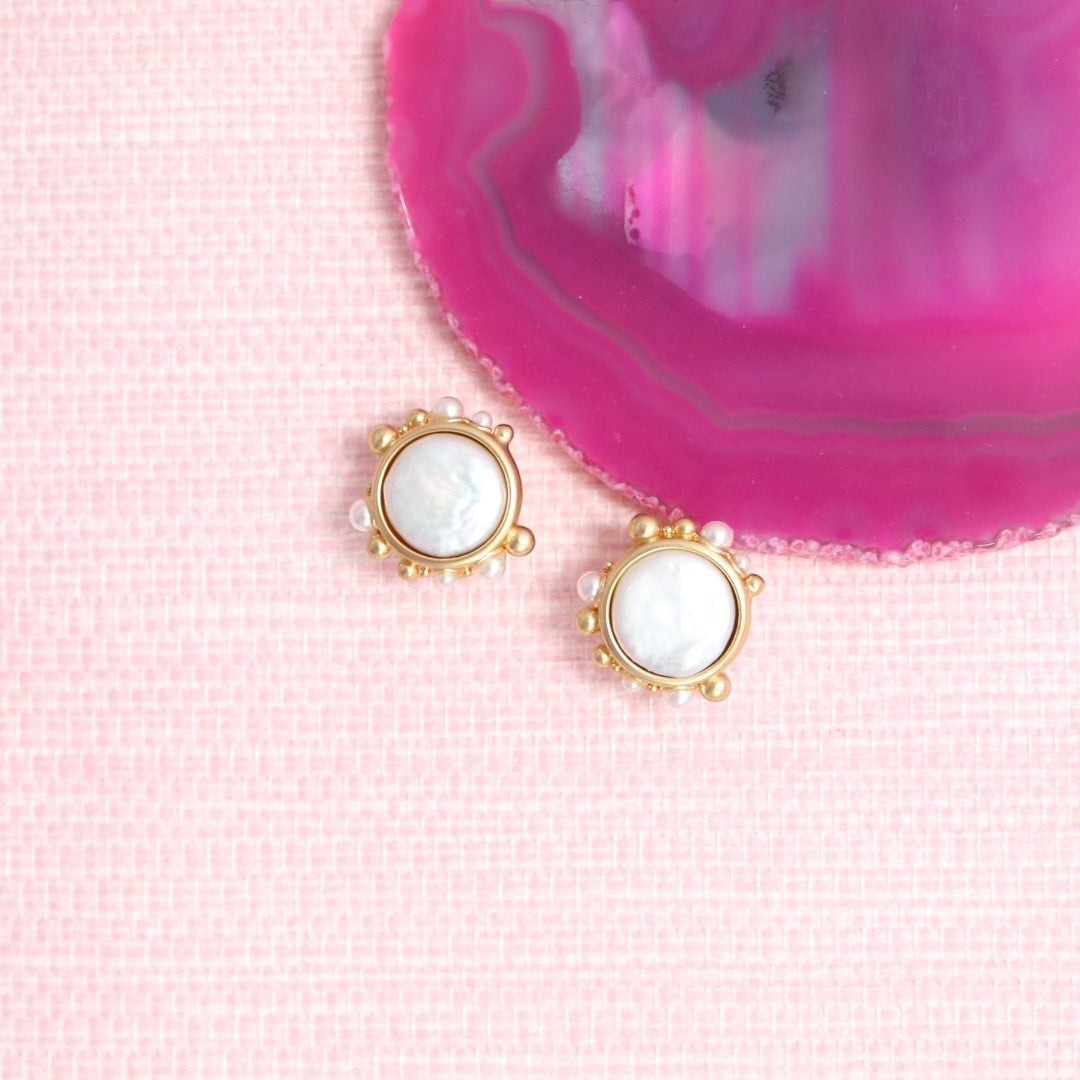 Porto pearl stud earrings on a pink background