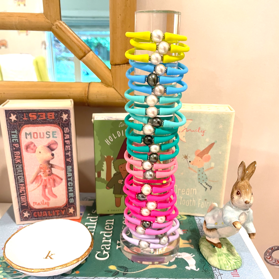 Clear bracelet tower filled with colorful silicone bracelets on a dresser